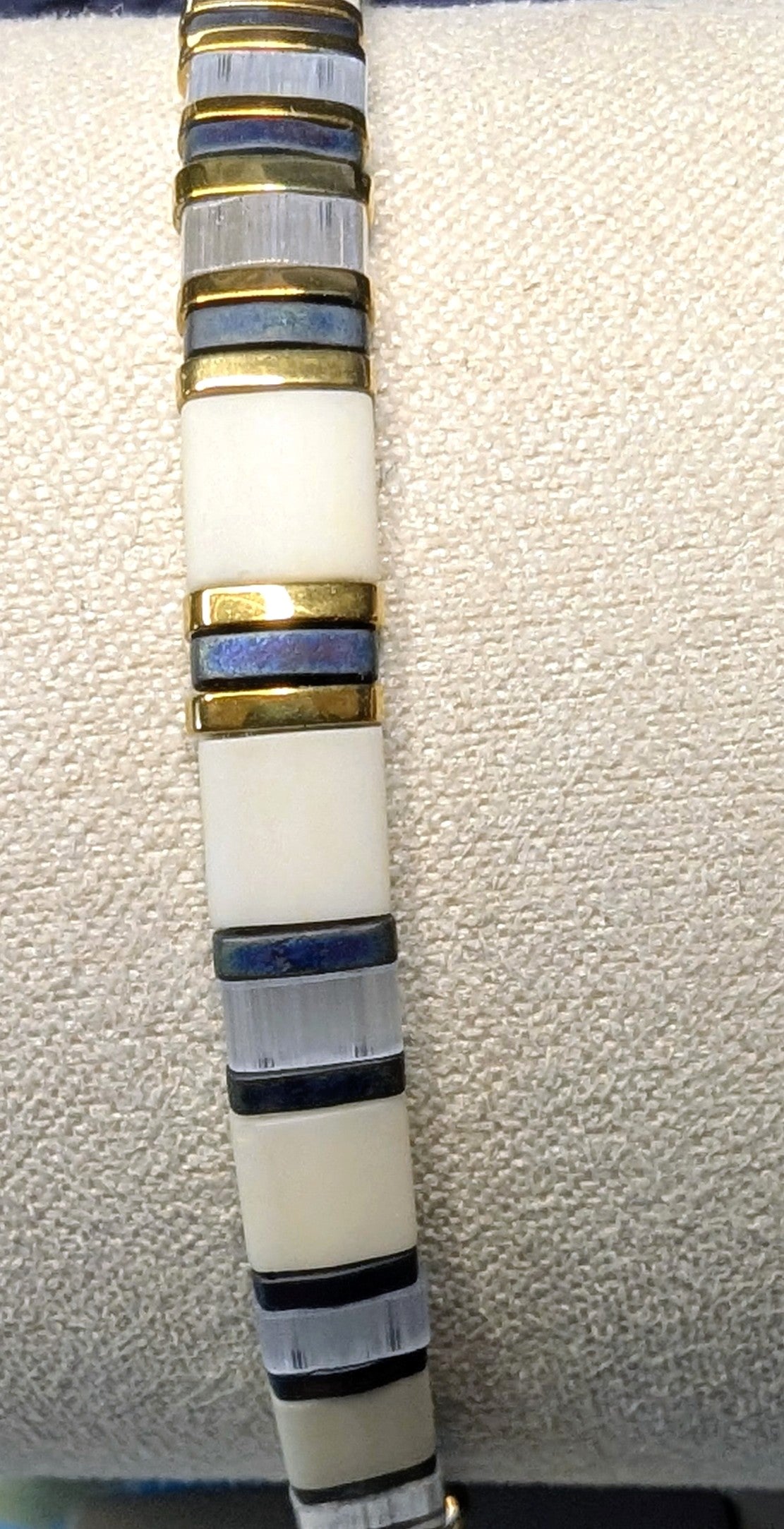 Bracelet Aokin, zoom sur le mélange de couleurs Gris bleu, blanc et doré.