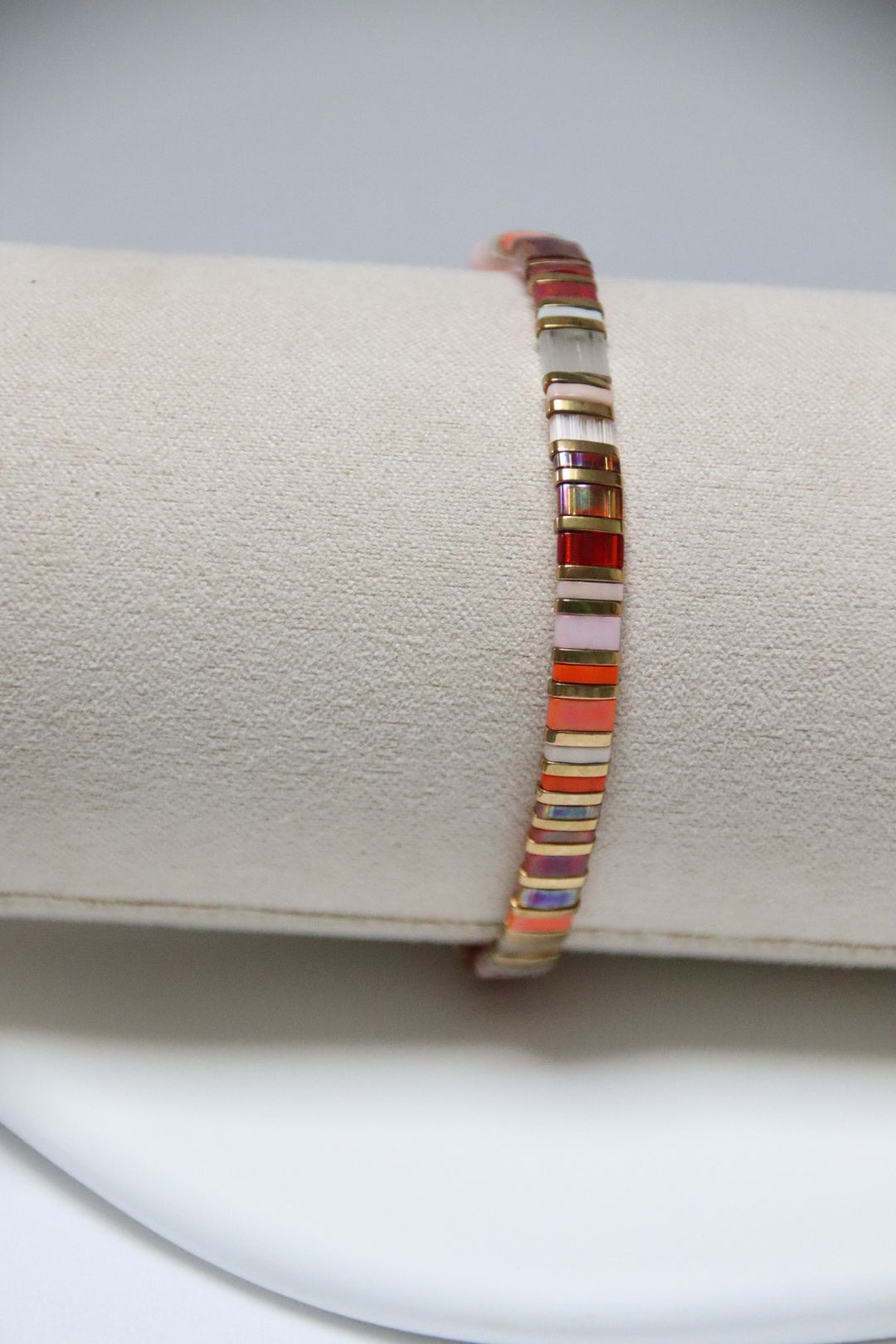 Bracelet AyaKin en perles de verre plates, camaïeu de rose, orange, rouge et doré. Vue verticale