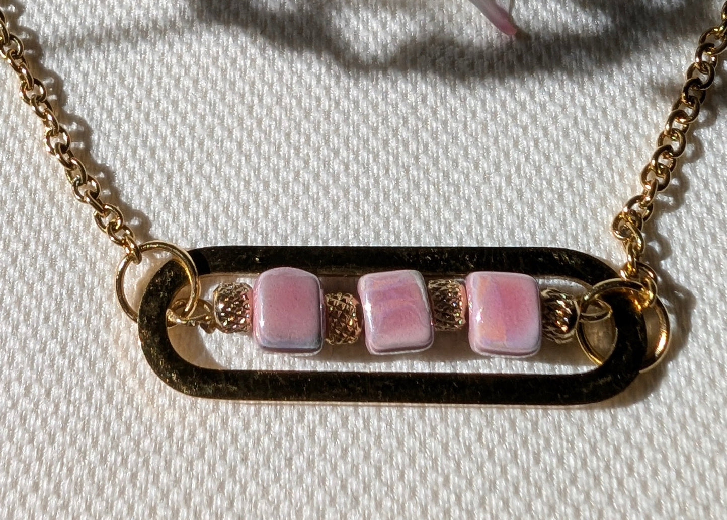 ros plan sur le collier Roséa, mettant en valeur les détails des perles en céramique rose et des perles dorées finement ciselées.