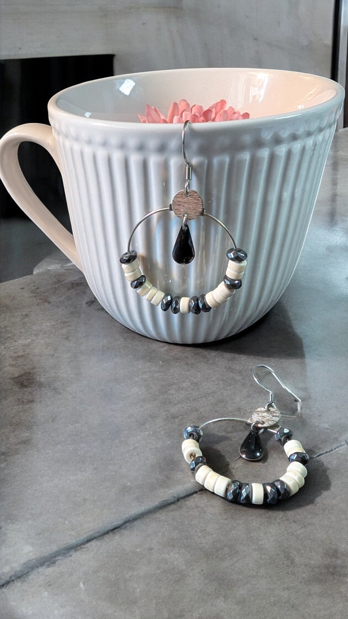Boucles d'oreilles Céleste en acier inoxydable, avec perles d’howlite ivoire et hématite grise sur un cercle argenté.
