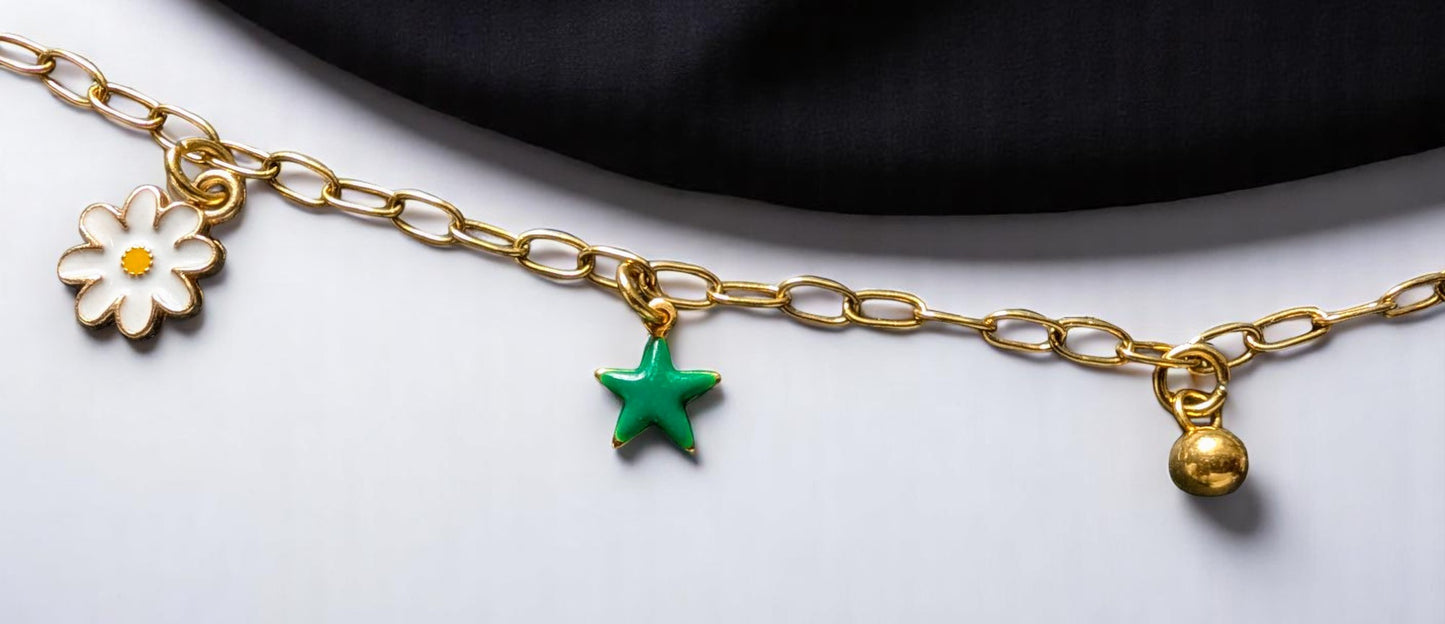Zoom sur les pendentifs du collier Lucéa – Boule, étoile, fleur.