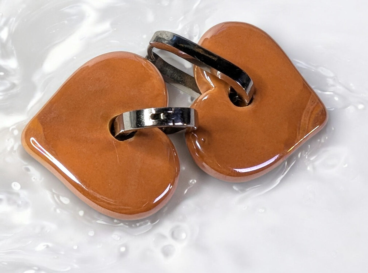 Boucles d'oreilles céramique cœur orange, créole ovale en acier inoxydable argenté, bijoux modernes et stylés.