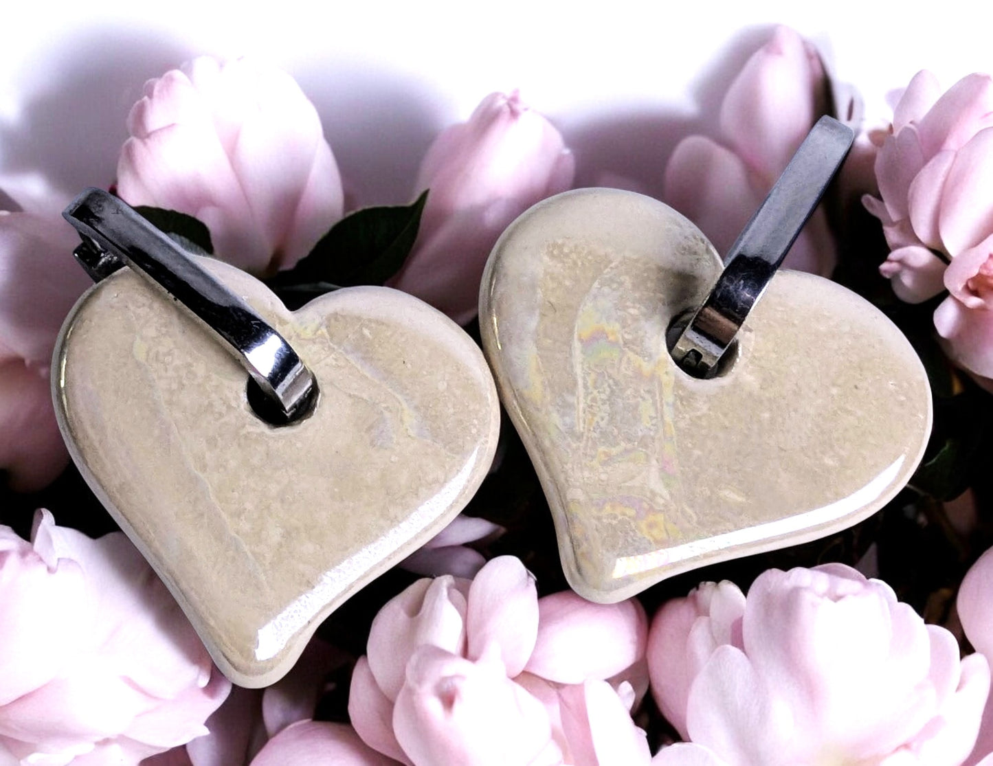 Boucles d'oreilles en céramique cœur blanc cassé sur créole ovale argentée, design élégant et moderne.