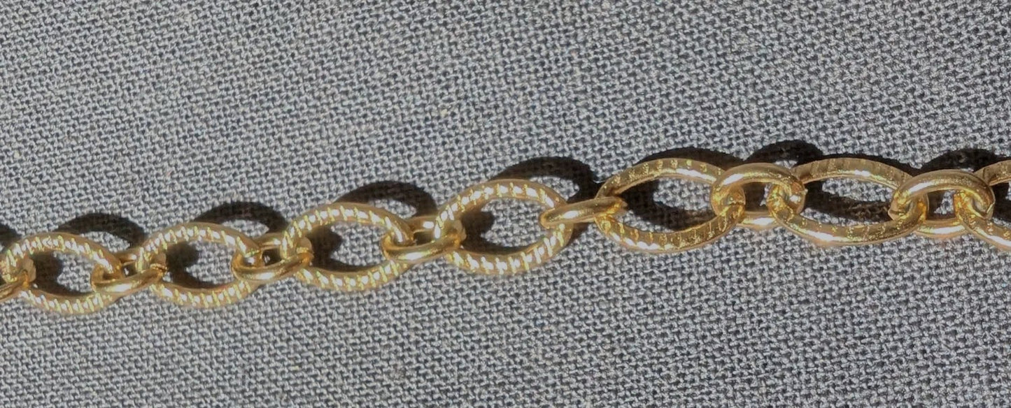 Zoom sur la chaîne ovale striée du collier Majorque, mettant en valeur sa texture élégante et originale.