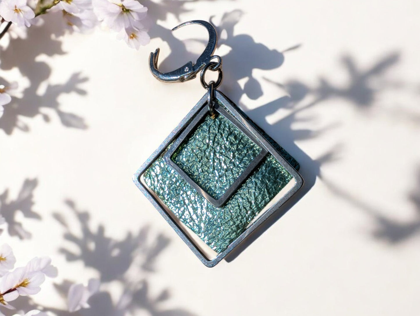 Zoom sur une des Boucles d'oreilles Emeraude en cuir vert texturé et acier inoxydable.