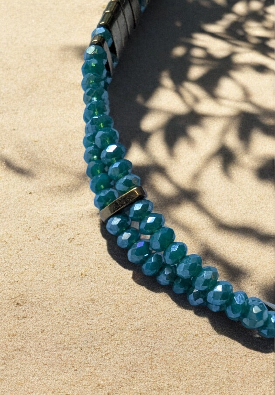 Bracelet fin élastiqué sur deux rangées de perles de verre à facettes, bijou élégant et raffiné.