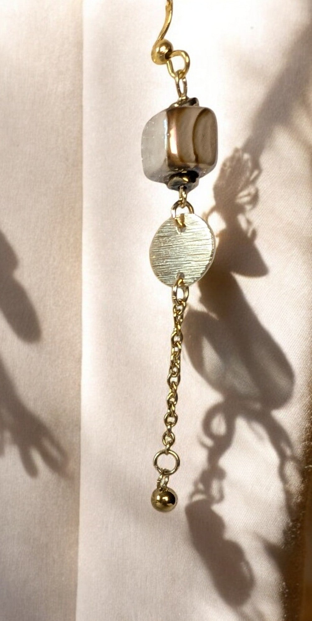 Boucles d'oreilles dorées en métal avec perle céramique et chainetteant et intemporel.