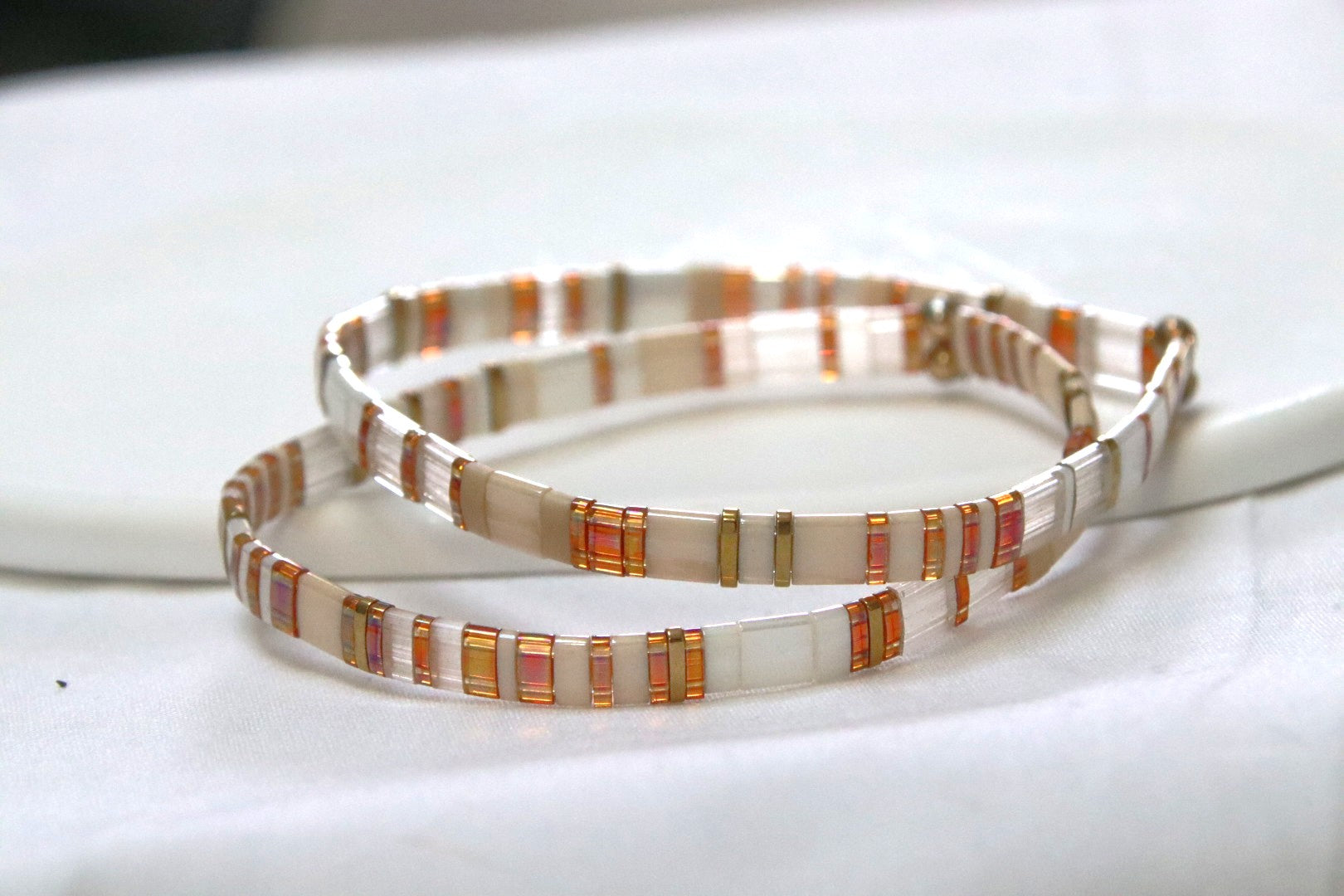 Bracelets Akari en perles topaze foncée, blanches, crème et dorées, doux et lumineux.