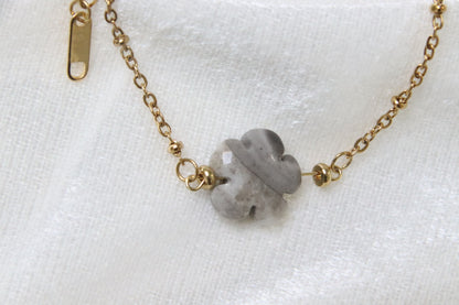 Gros plan sur bracelet en agate grise en forme de fleur.