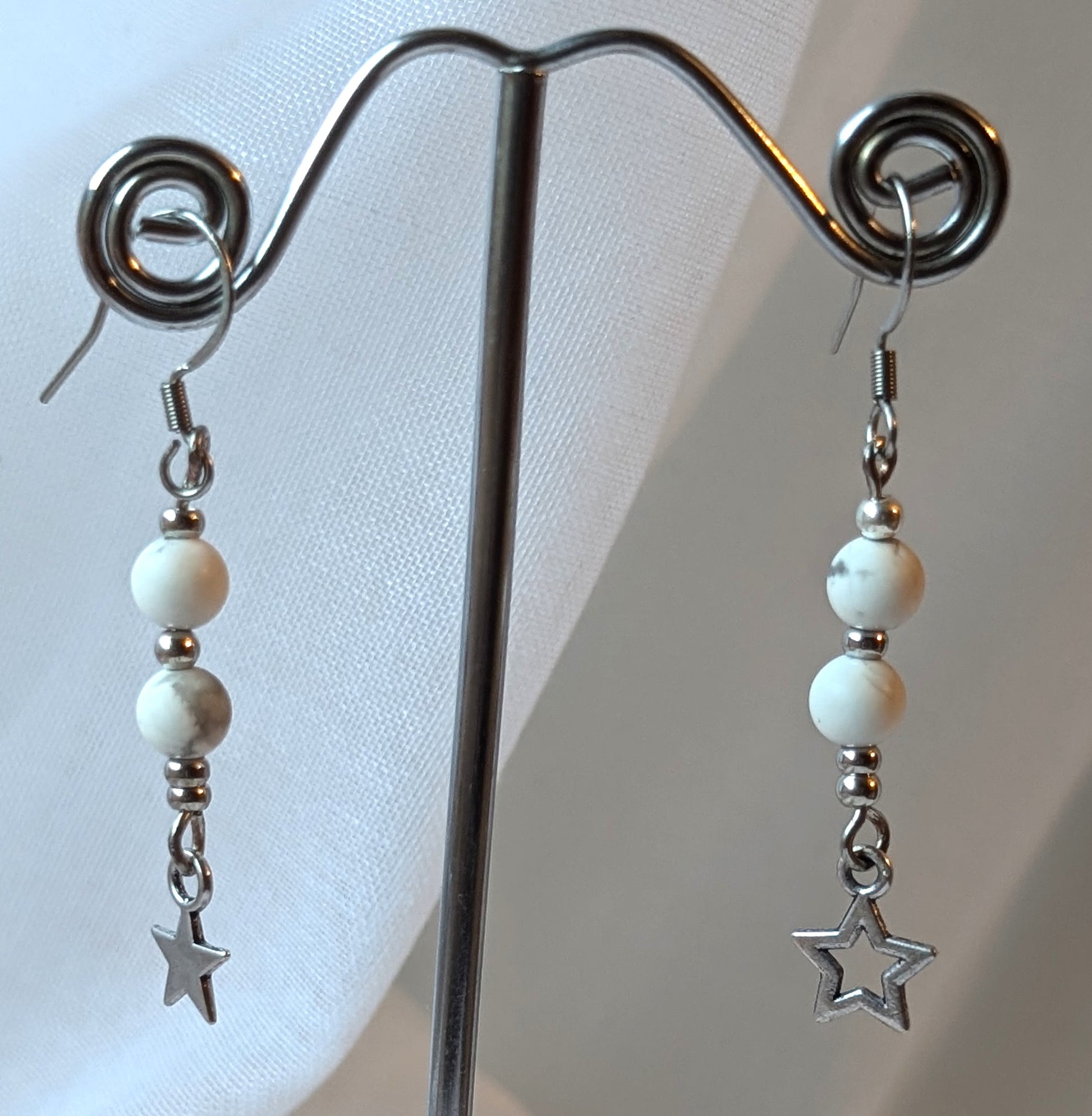 Boucles d'oreilles Étoiles Polaires en acier inoxydable avec perles de howlite blanche et étoiles, élégantes et légères.