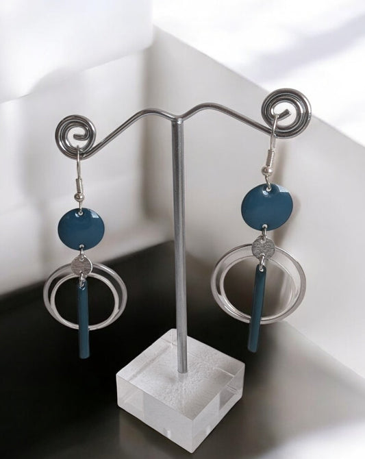 Boucles d’oreilles Infini Bleu en acier inoxydable argenté avec connecteur en laiton émaillé bleu canard, et plusieurs cercles en acier inoxydable, design minimaliste et élégant.