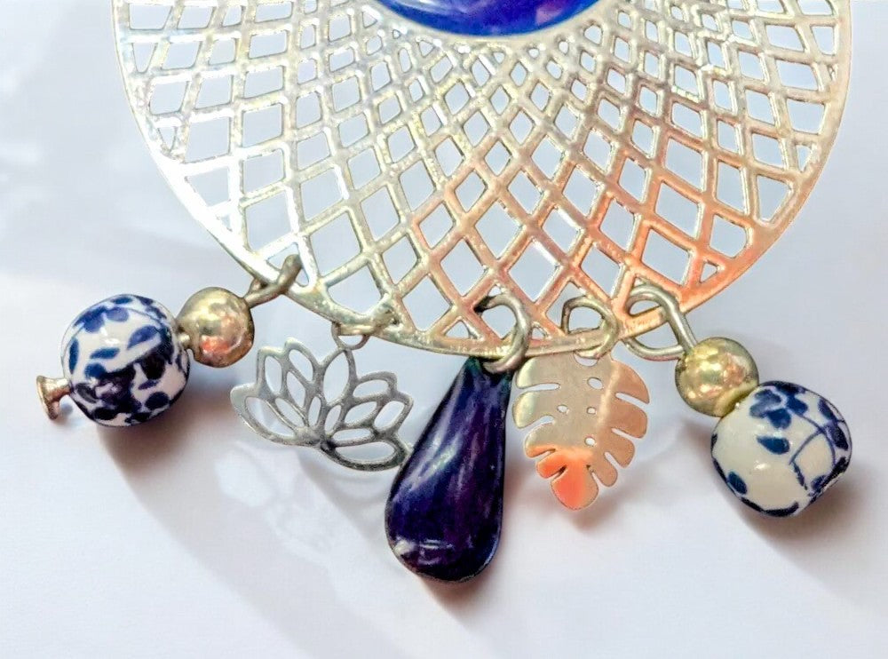 Zoom sur un Bijou raffiné : boucles pendantes Jardin d’Azur ornées de motifs floraux en céramique et de sequins émaillés bleu azur.

