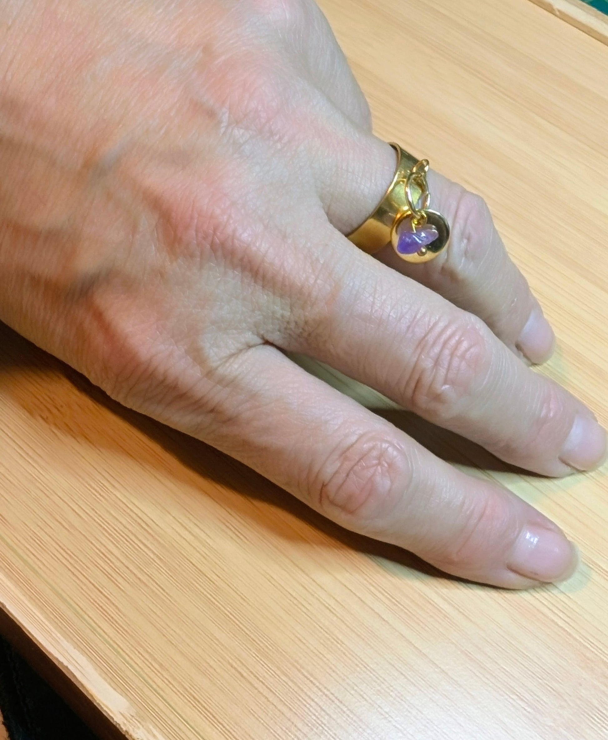 bague ajustable dorée améthyste portée au doigt