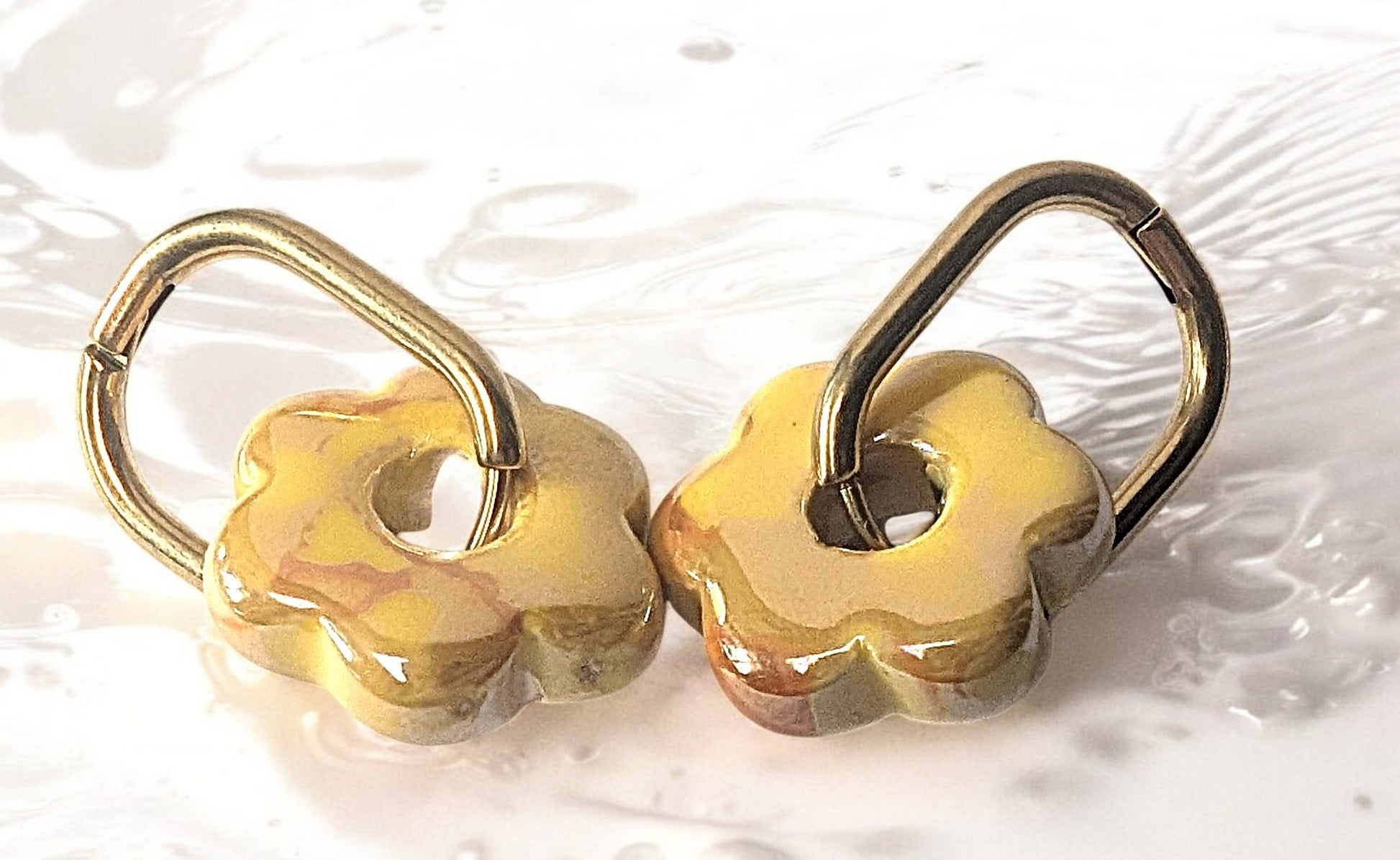 Boucles d'oreilles fleur en céramique jaune avec créoles dorées en acier inoxydable. Absolument craquant.