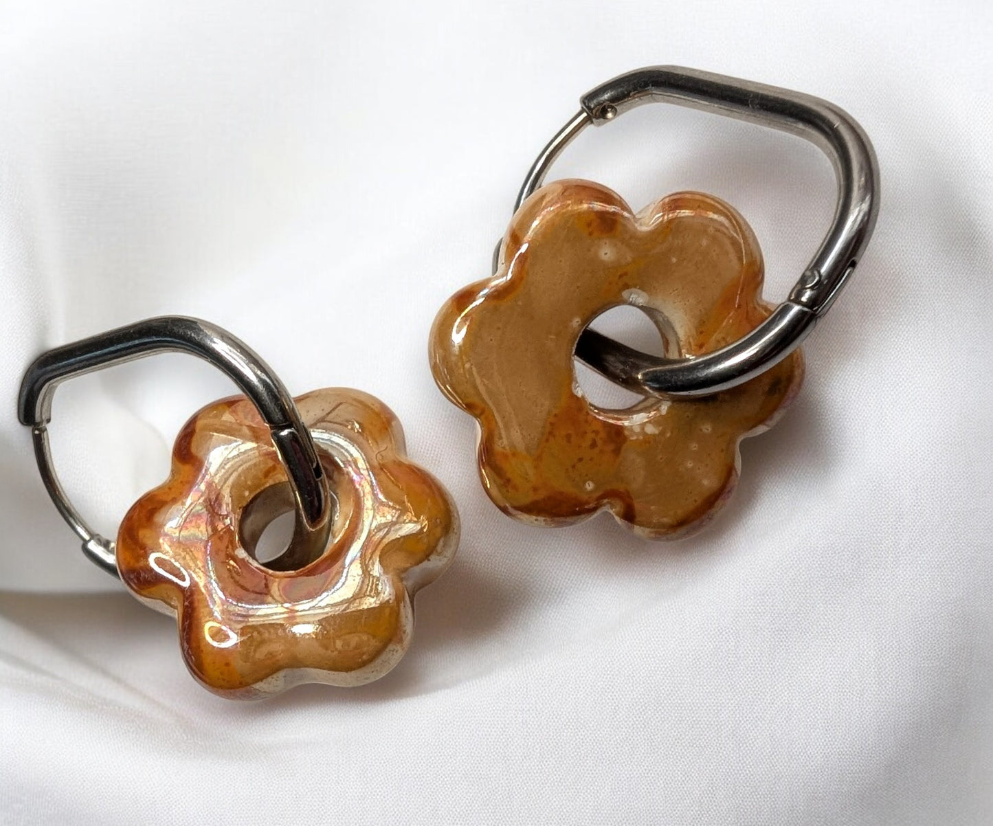 Boucles d'oreilles fleur en céramique orange avec créoles argentées en acier inoxydable. Des reflets chaleureux