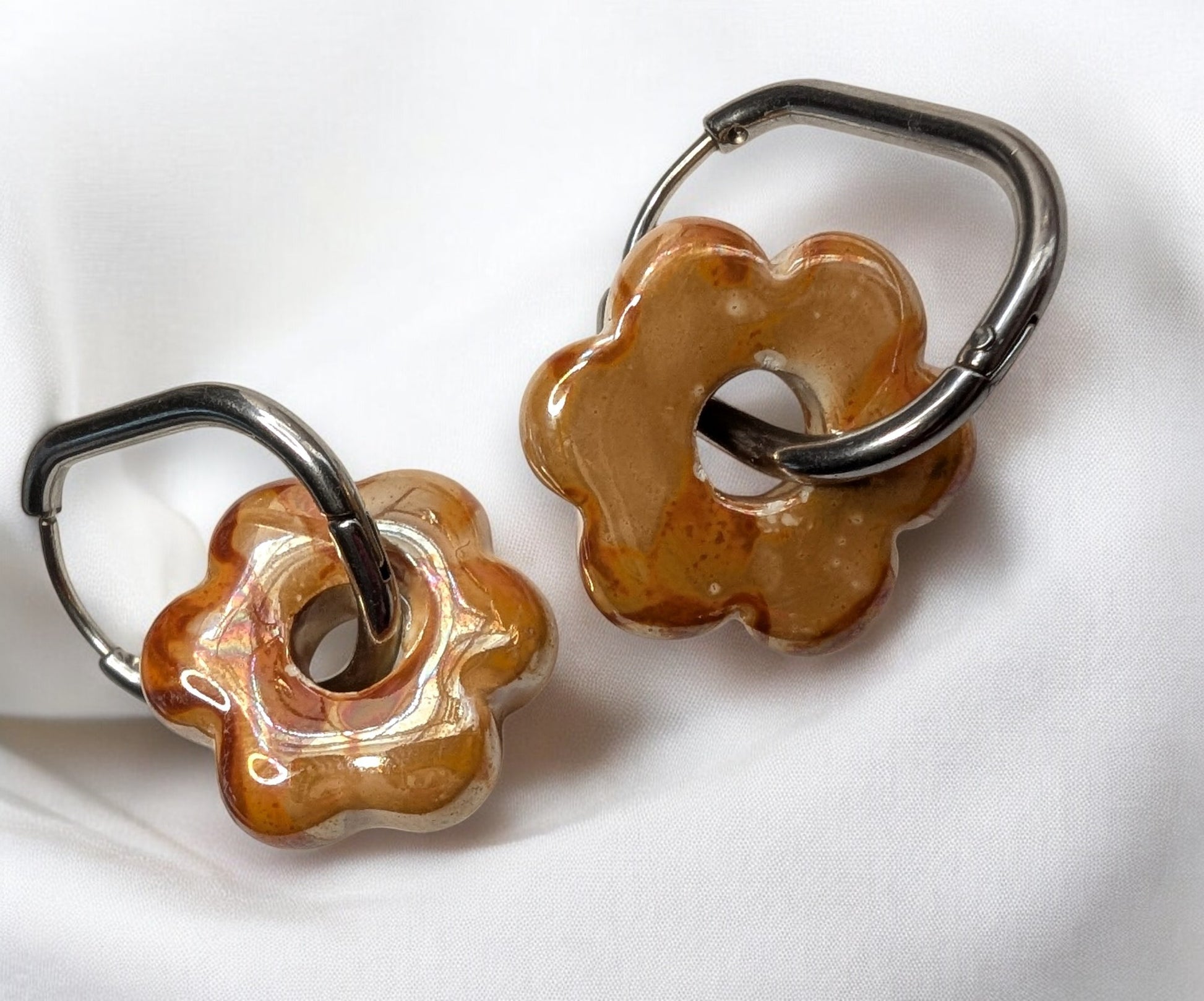 Boucles d'oreilles fleur en céramique orange avec créoles argentées en acier inoxydable. Des reflets chaleureux
