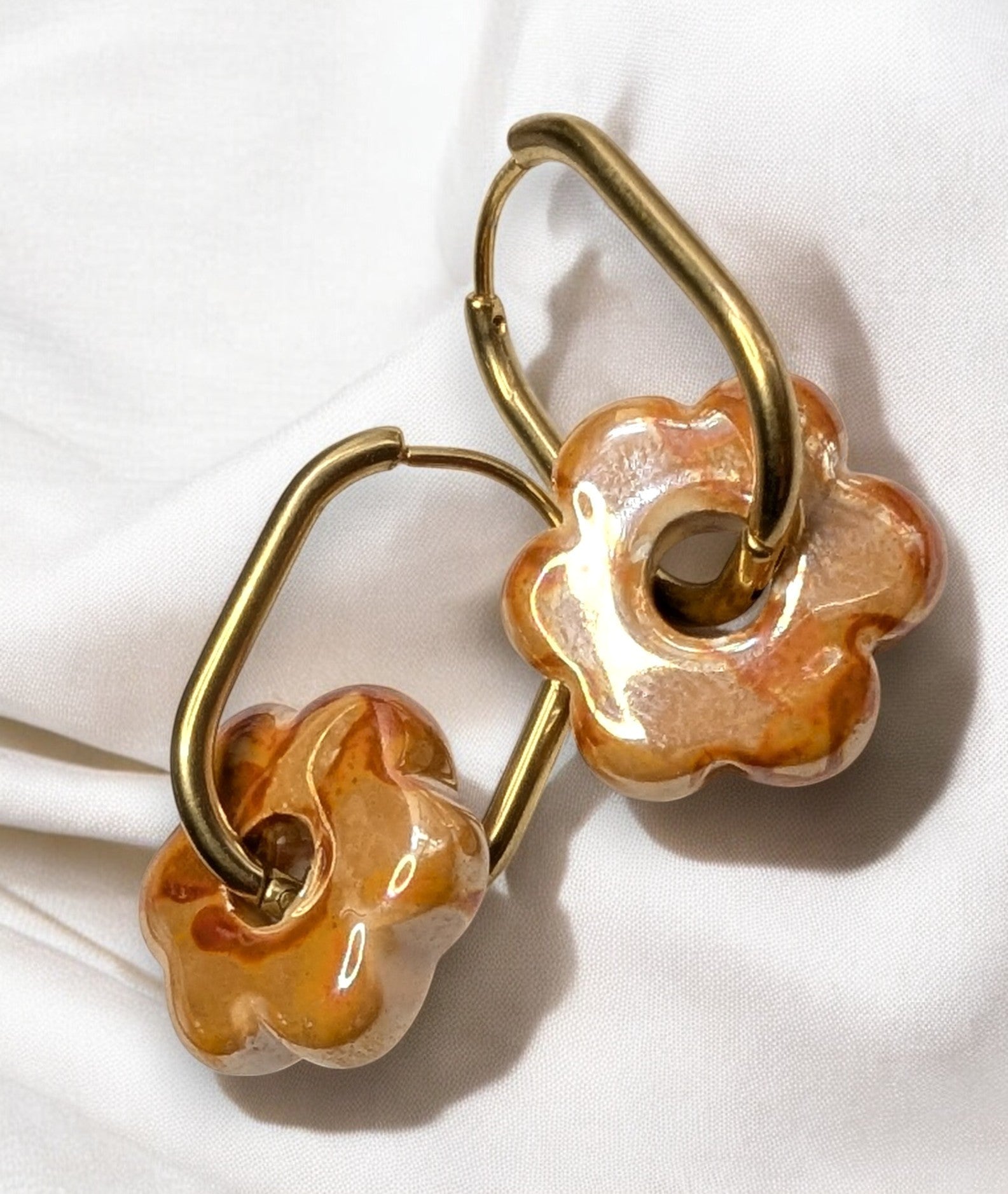 Boucles d'oreilles fleur en céramique orange avec créoles dorées en acier inoxydable. Look estival. 