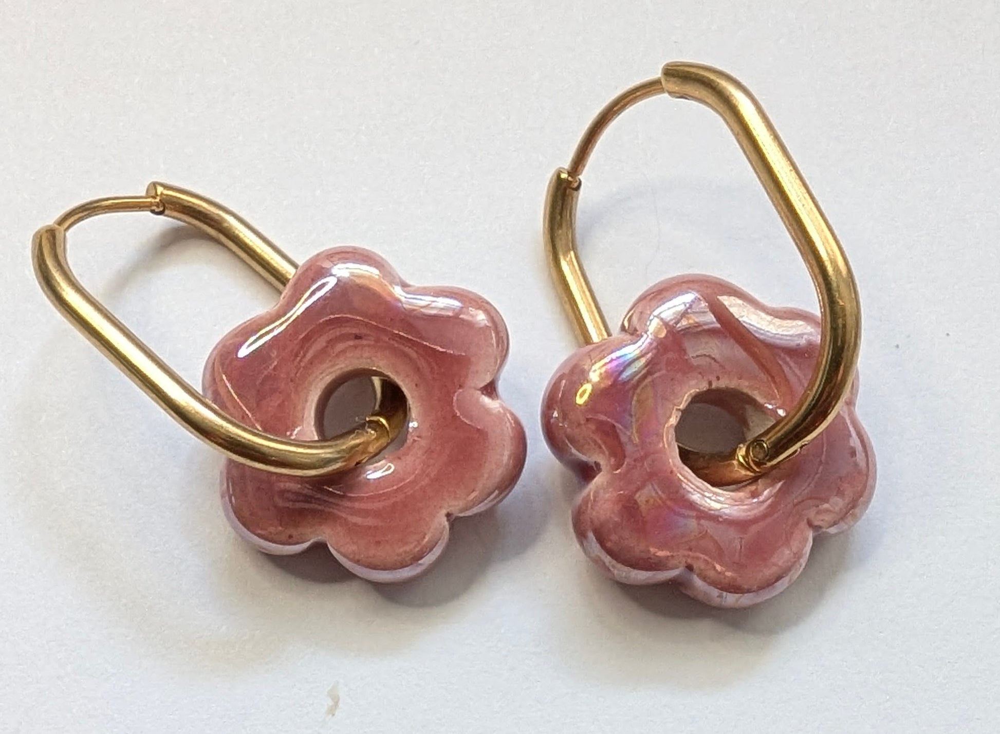 Boucles d'oreilles fleur en céramique rose magenta avec créoles dorées en acier inoxydable. Fines et élégantes 