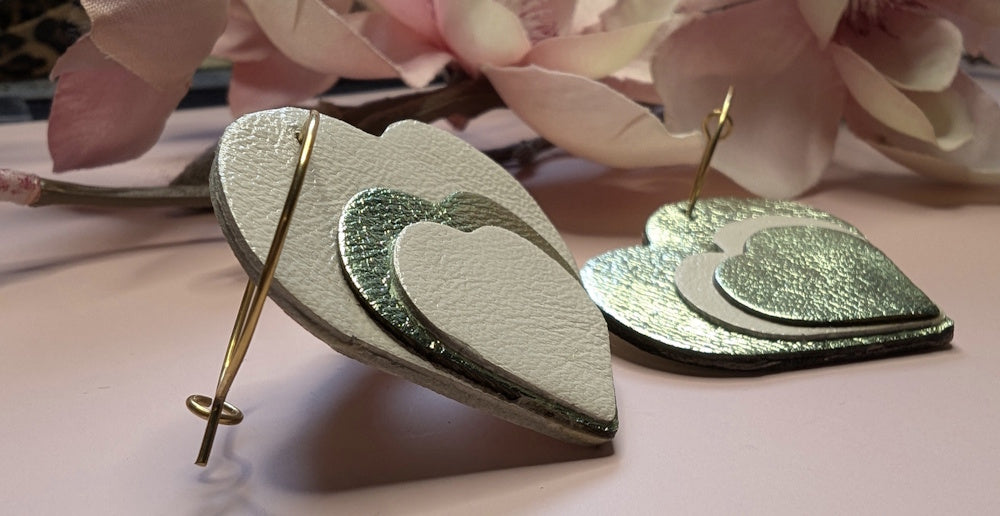 Boucles d’oreilles originales en cuir pour femme, modèle Evanéa. Vue de profil sur un fond fleuri