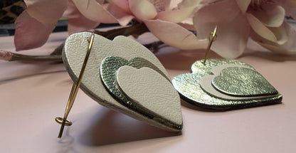 Boucles d’oreilles originales en cuir pour femme, modèle Evanéa. Vue de profil sur un fond fleuri