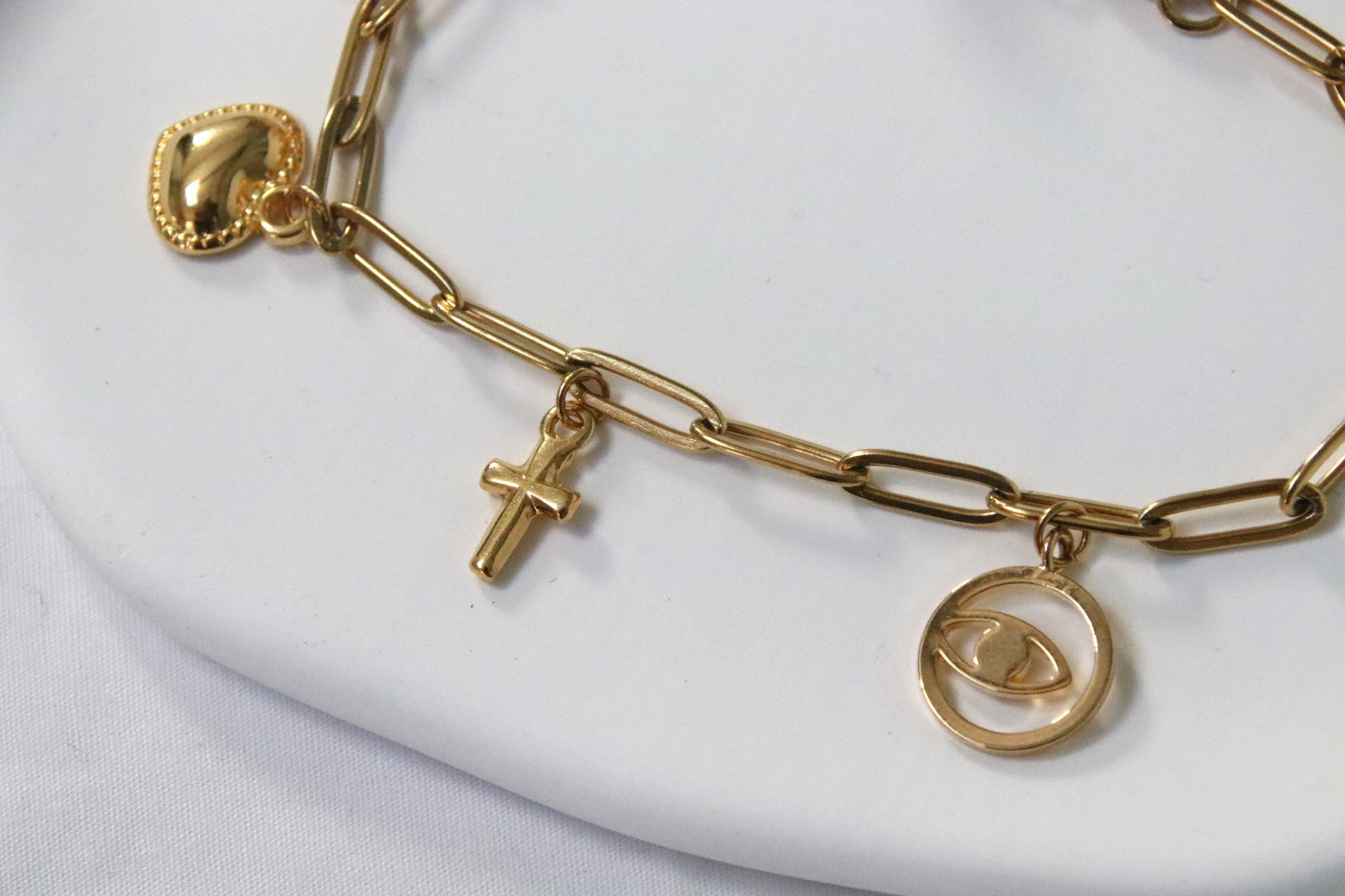 Bracelet Erina aux bords arrondis, charms croix, cœur et œil, style moderne