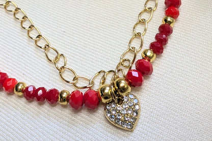 Bracelet Nola perles de verre facettées rouge et orangées avec cœur strass. Détail cœur et stras