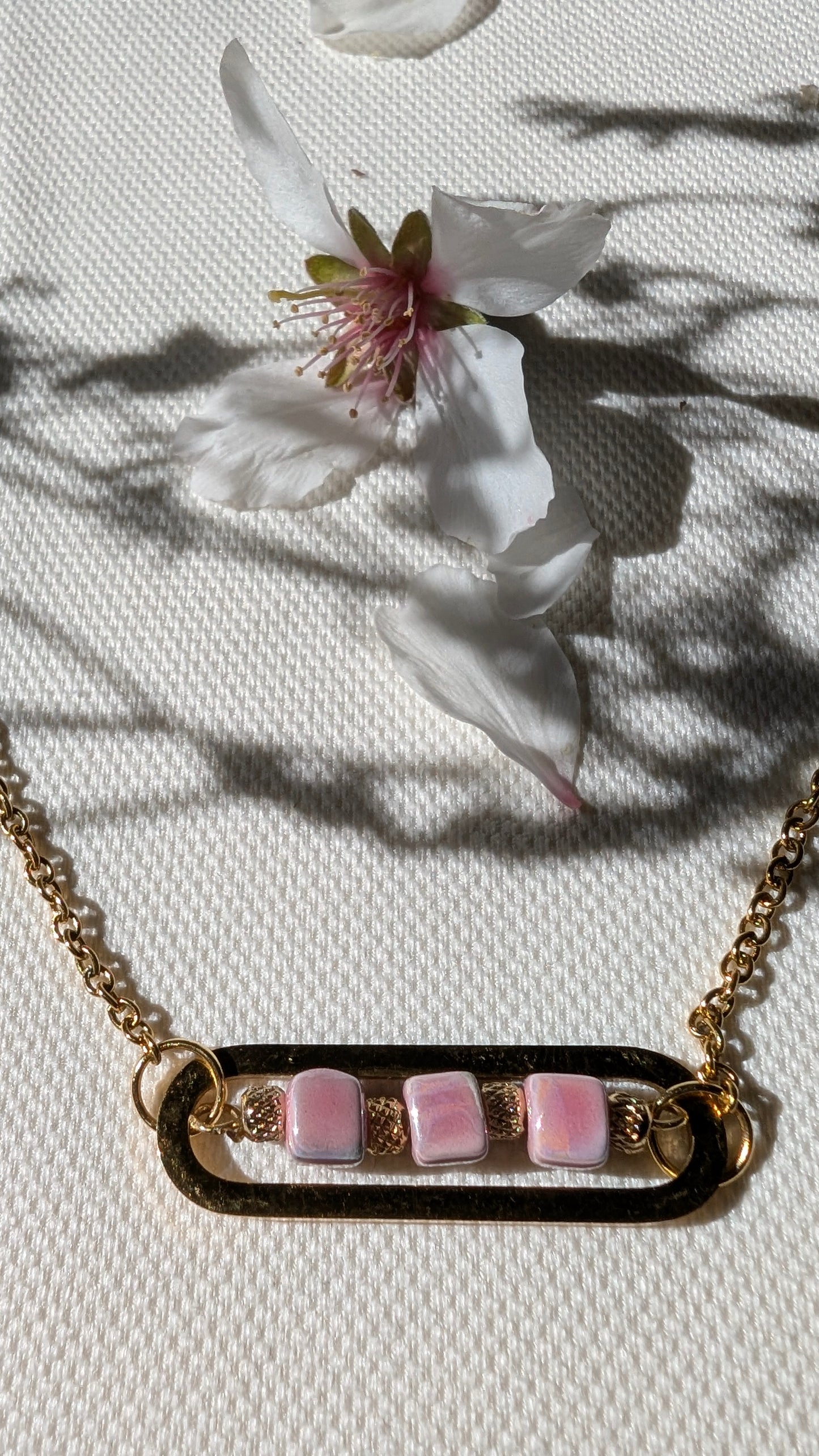 Zoom sur les perles de céramique, les ciselées et la chaîne dorée du bracelet Roséa, pour une touche élégante et lumineuse.