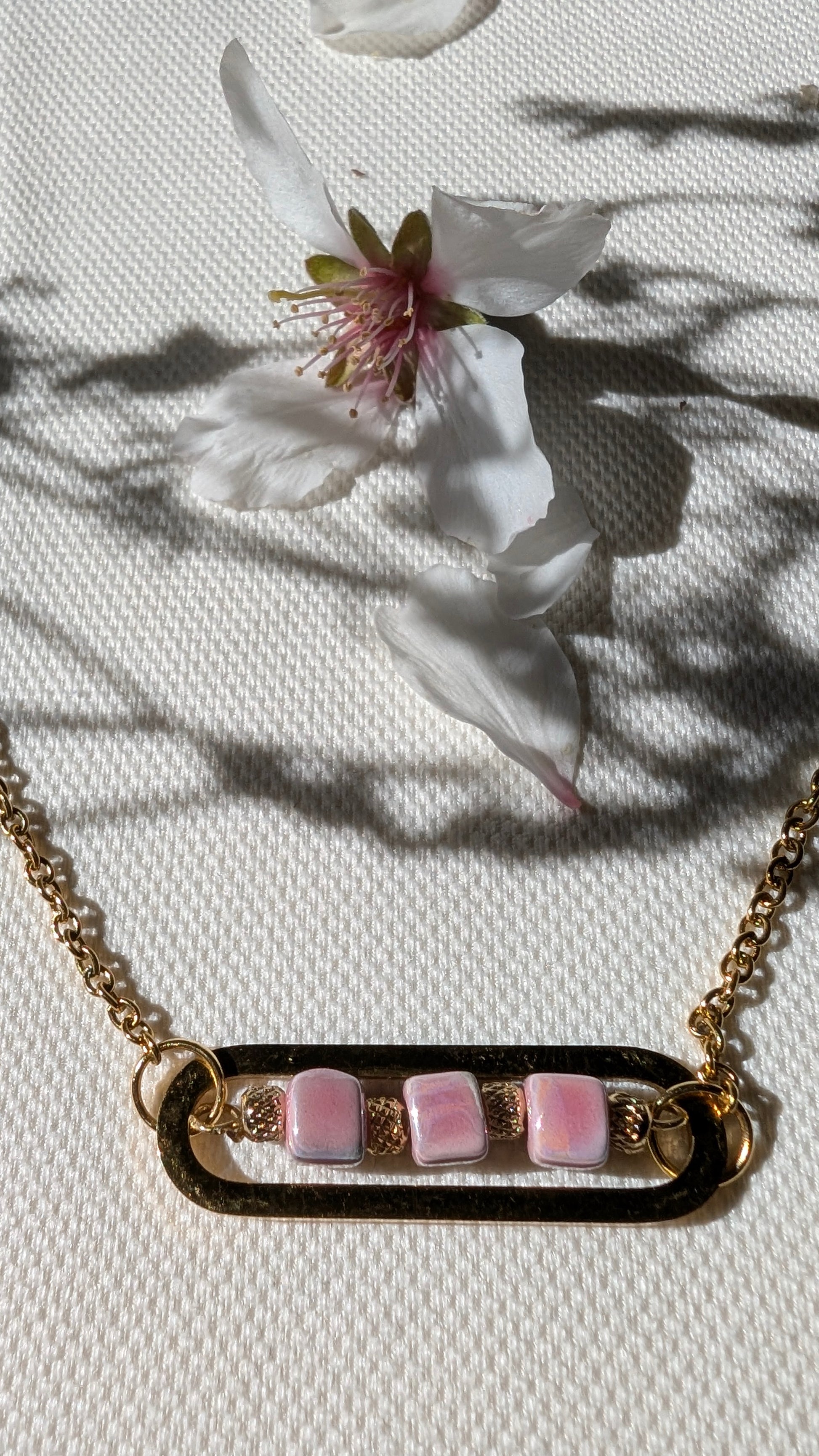 Zoom sur les perles de céramique, les ciselées et la chaîne dorée du bracelet Roséa, pour une touche élégante et lumineuse.