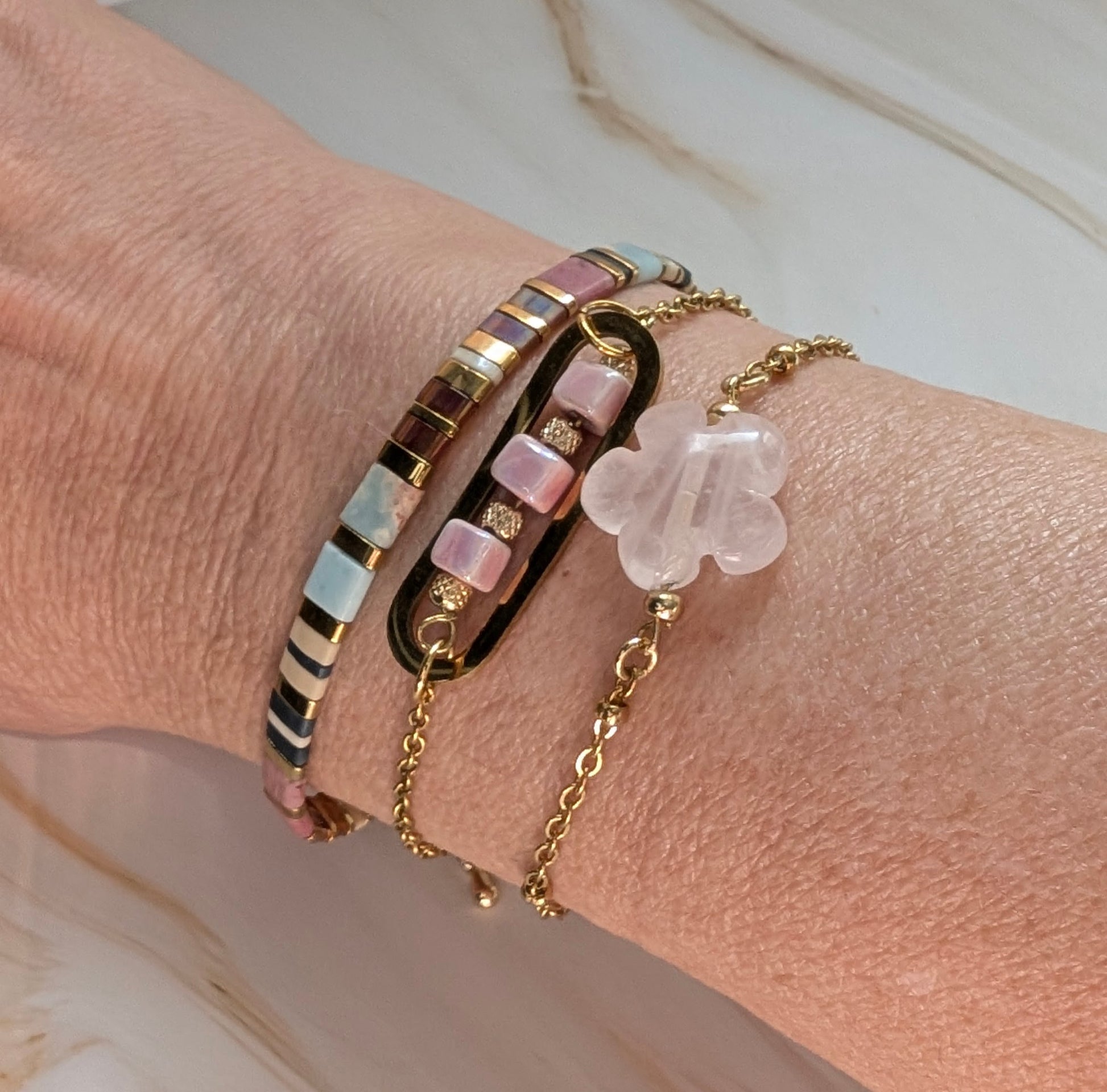 Bracelet Roséa porté au poignet, délicat et sophistiqué pour un look intemporel. Ici accompagné du bracelet Délia et d'un bracelet en perles de verre tons roses. 