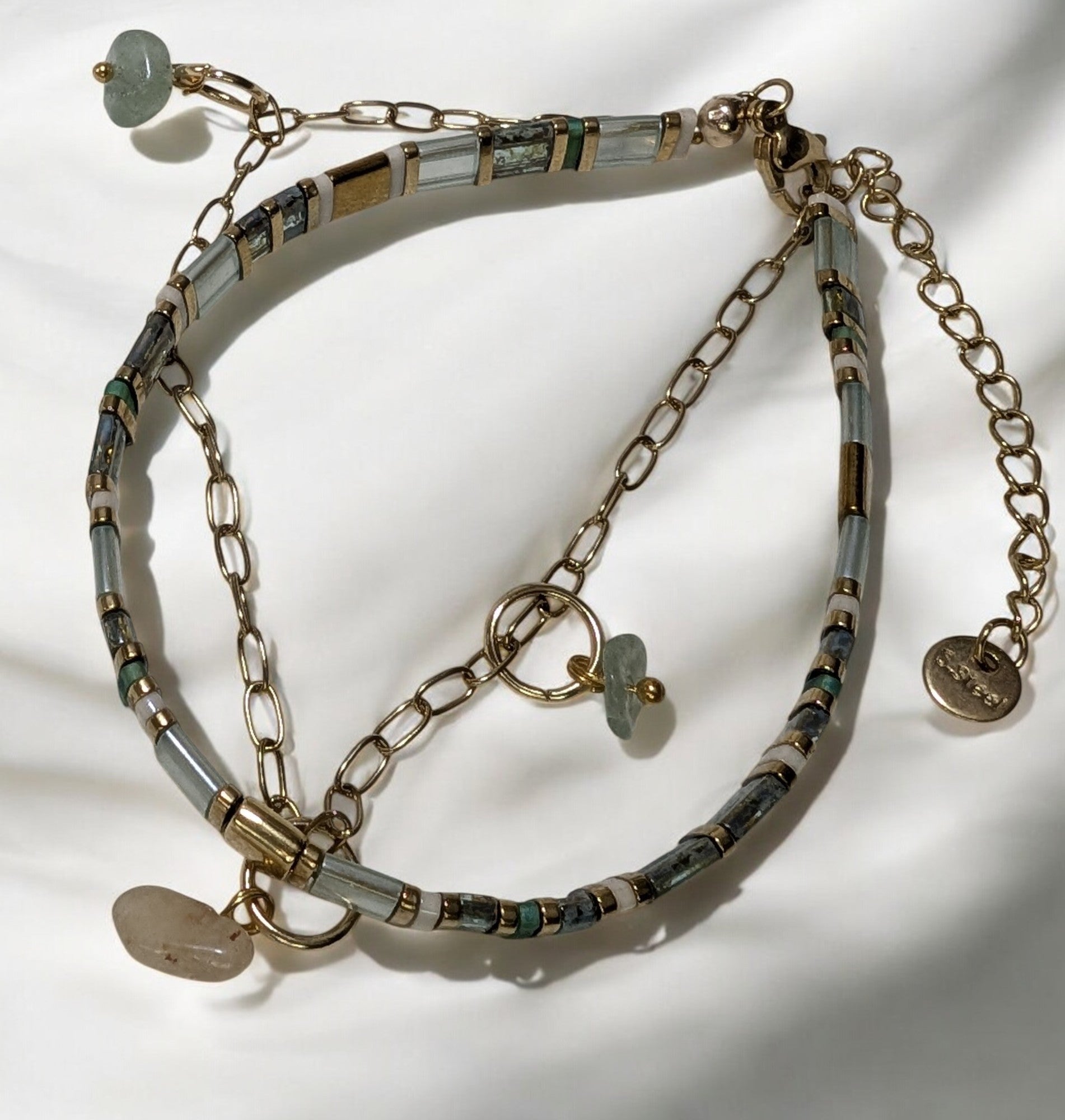 Zoom sur les mini charms en pierres gemmes, révélant leurs nuances naturelles et leur éclat.