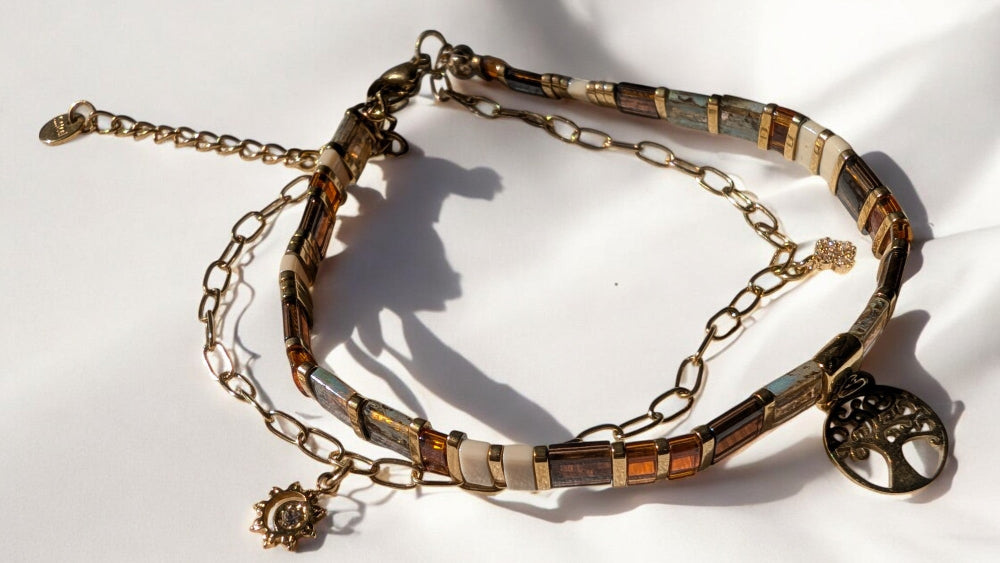 Détail du bracelet porté, avec ses charms en zircons scintillants qui captent la lumière.