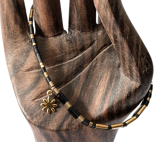 Bracelet élastique Perles du Japon noir breloque fleur. Élégance absolue et raffinement contrasté, un duo puissant et sophistiqué.