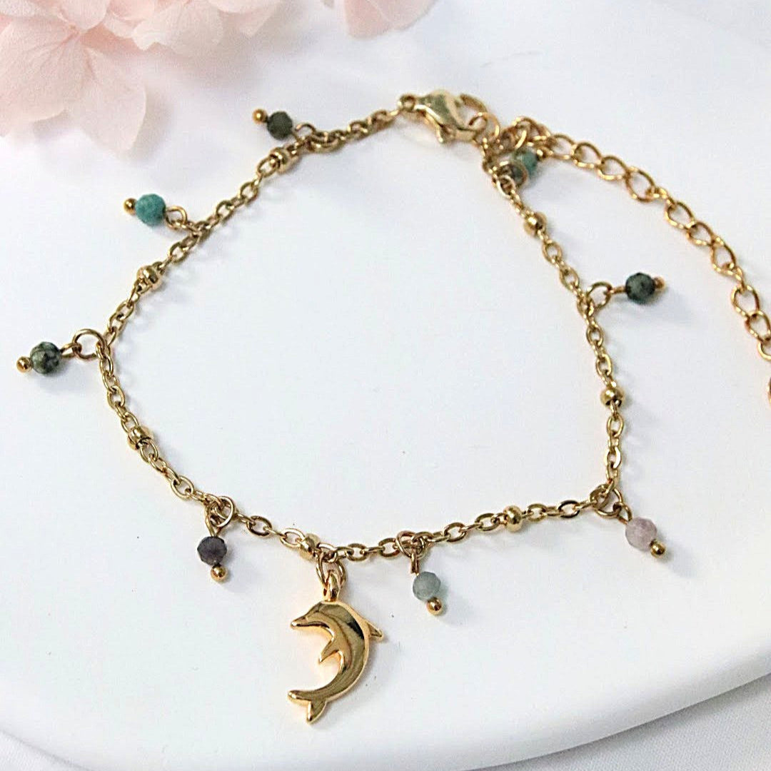 Bracelet Delphia en maille dorée fine avec dauphin central et charms en pierres naturelles