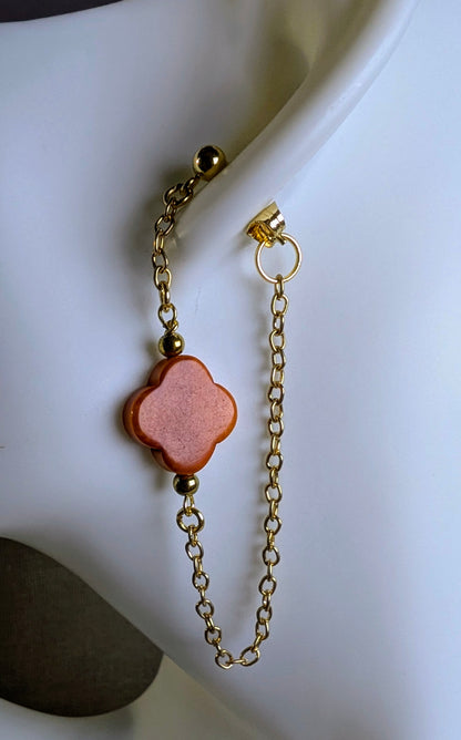 Boucles d’oreilles Cléa zoom sur le  trèfle  orange et chaine dorée.