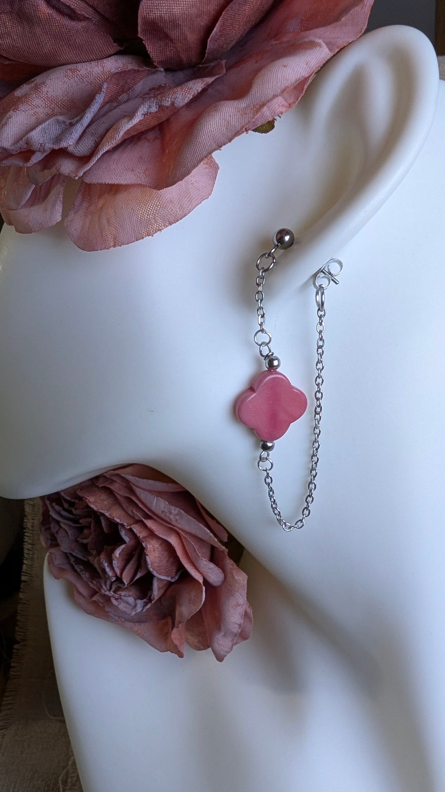 Boucles d’oreilles Cléa en acier inoxydable doré ou argenté, avec perle de Tagua en forme de trèfle et chaîne fine traversante pour un effet aérien. Ici trèfle rose et chaine argentée.