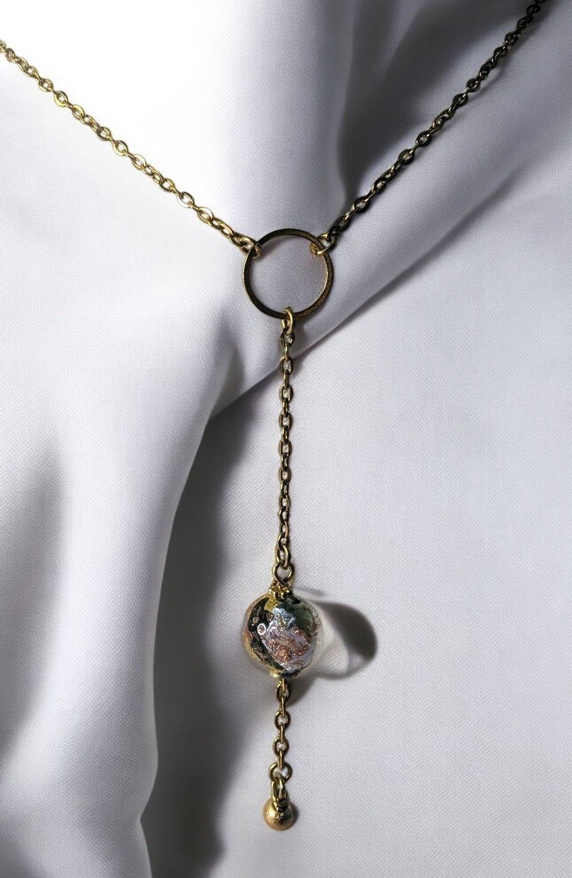 Détail du collier Vénézia : perle de Murano aux reflets vert, rosé, doré et argenté