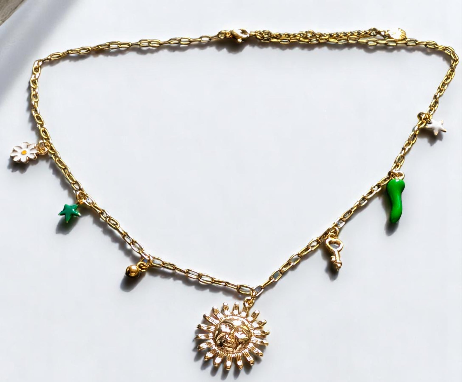 Collier doré Lucéa avec symboles soleil, étoile, fleur, clé et talisman