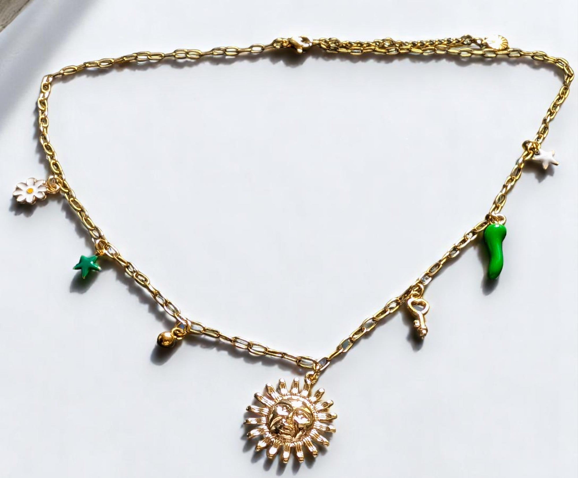 Collier doré Lucéa avec symboles soleil, étoile, fleur, clé et talisman