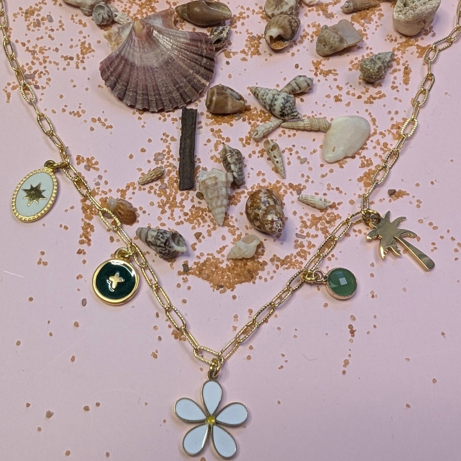 Le collier Liora, posé au milieu de coquillages et sable