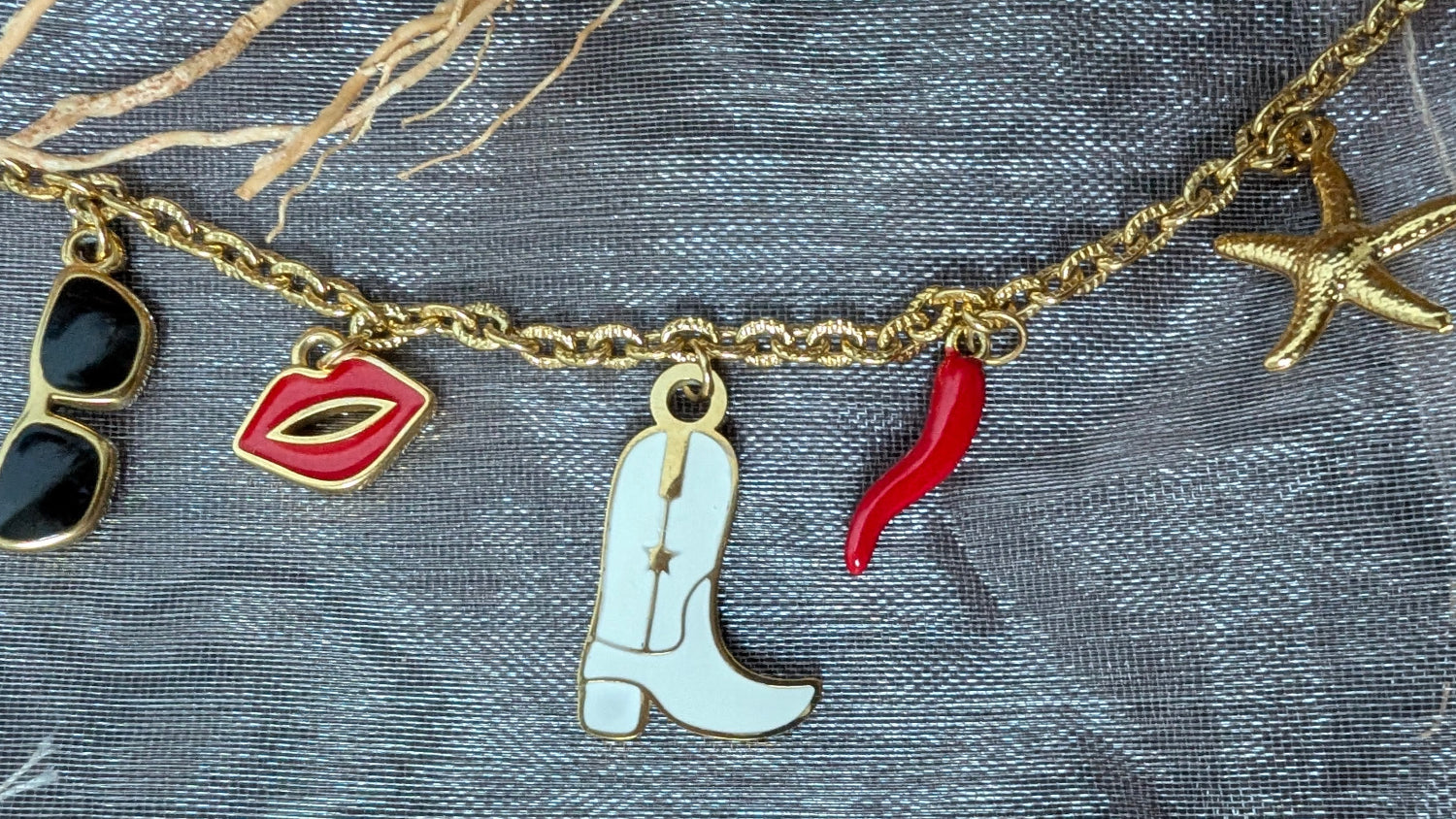 Collier Dolce Vita avec charms colorés : botte cowboy, lunettes, lèvres rouges, corne d’abondance et étoile de mer