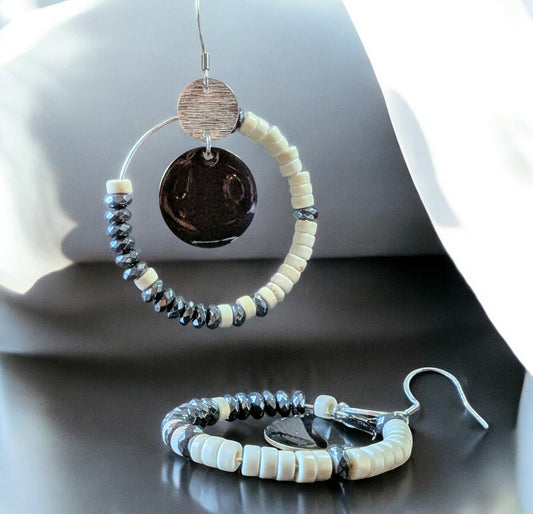 Boucles d’oreilles éclipse d'ivoire howlite et hématite, avec perles ivoire et métallisée montées sur un cercle en acier inoxydable. Ici photo zoomée 