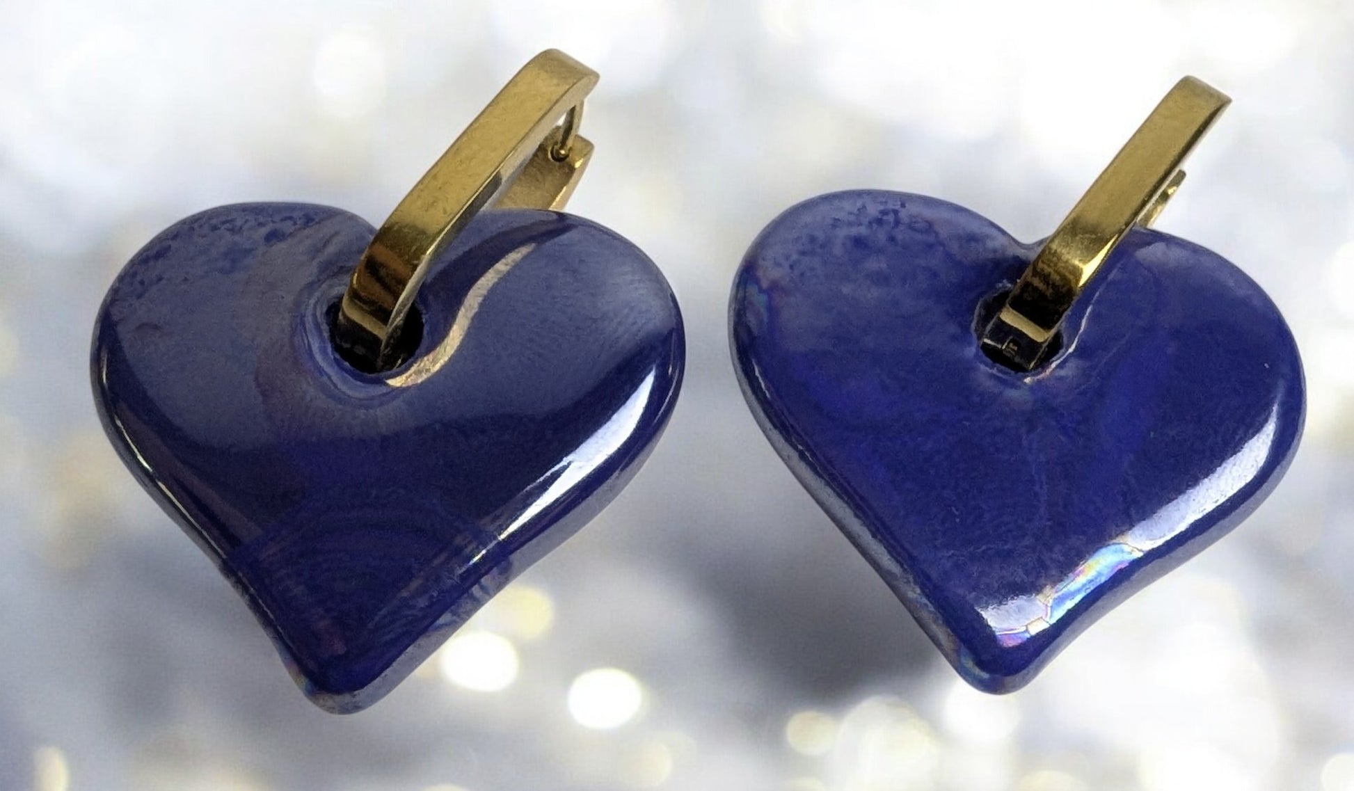 Boucles d'oreilles en céramique cœur bleu sur créole ovale dorée, design élégant et moderne.
