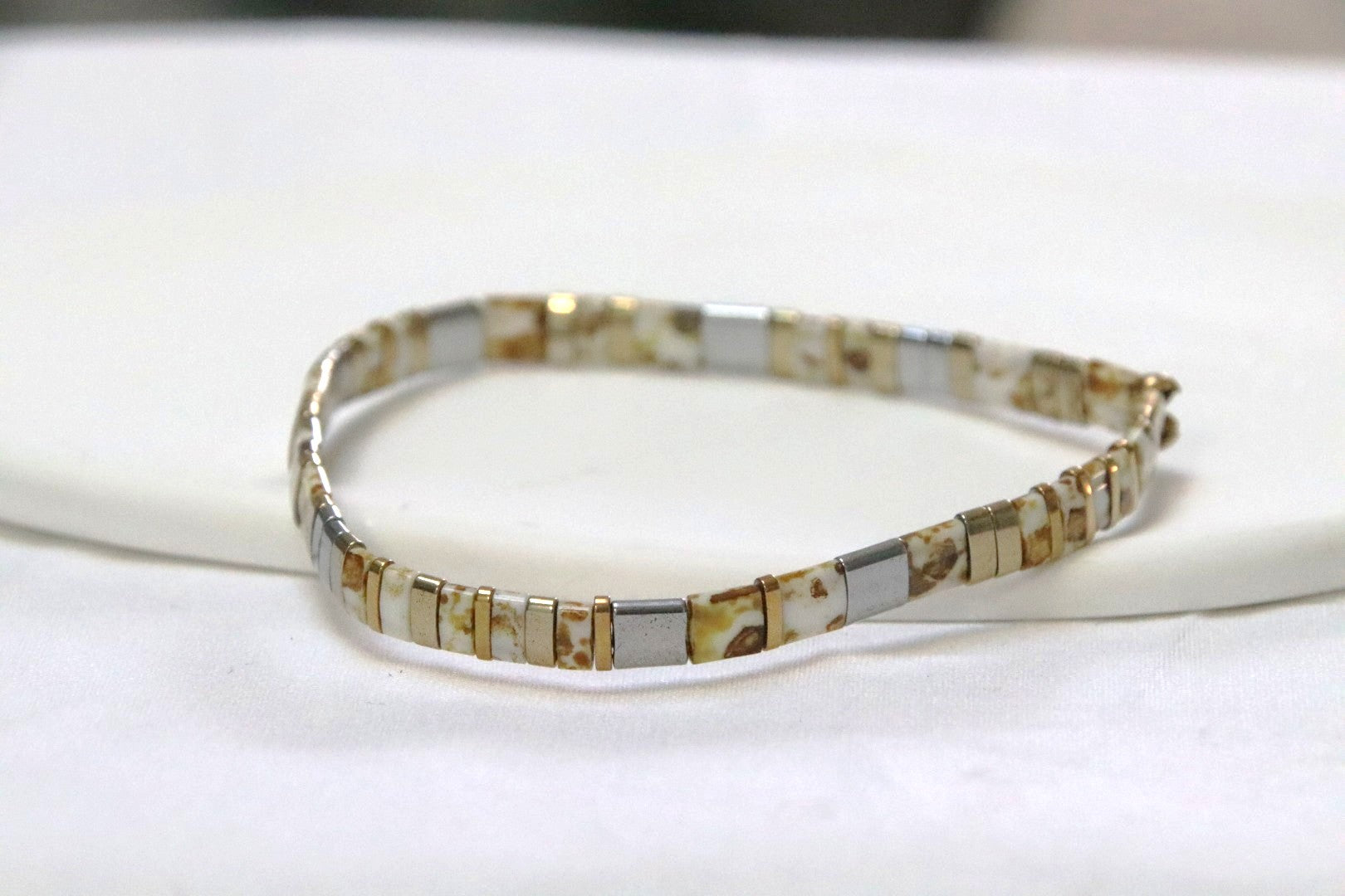 Bracelet GinKin en perles blanches tachetées de jaune, argentées et dorées, lumineux et moderne.
