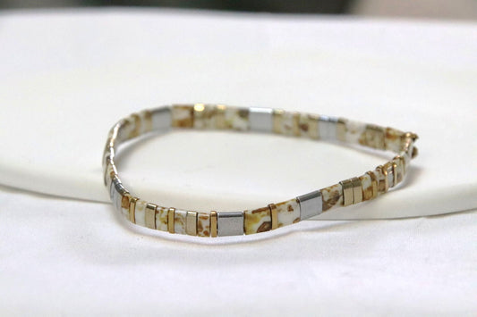 Bracelet GinKin en perles blanches tachetées de jaune, argentées et dorées, lumineux et moderne.