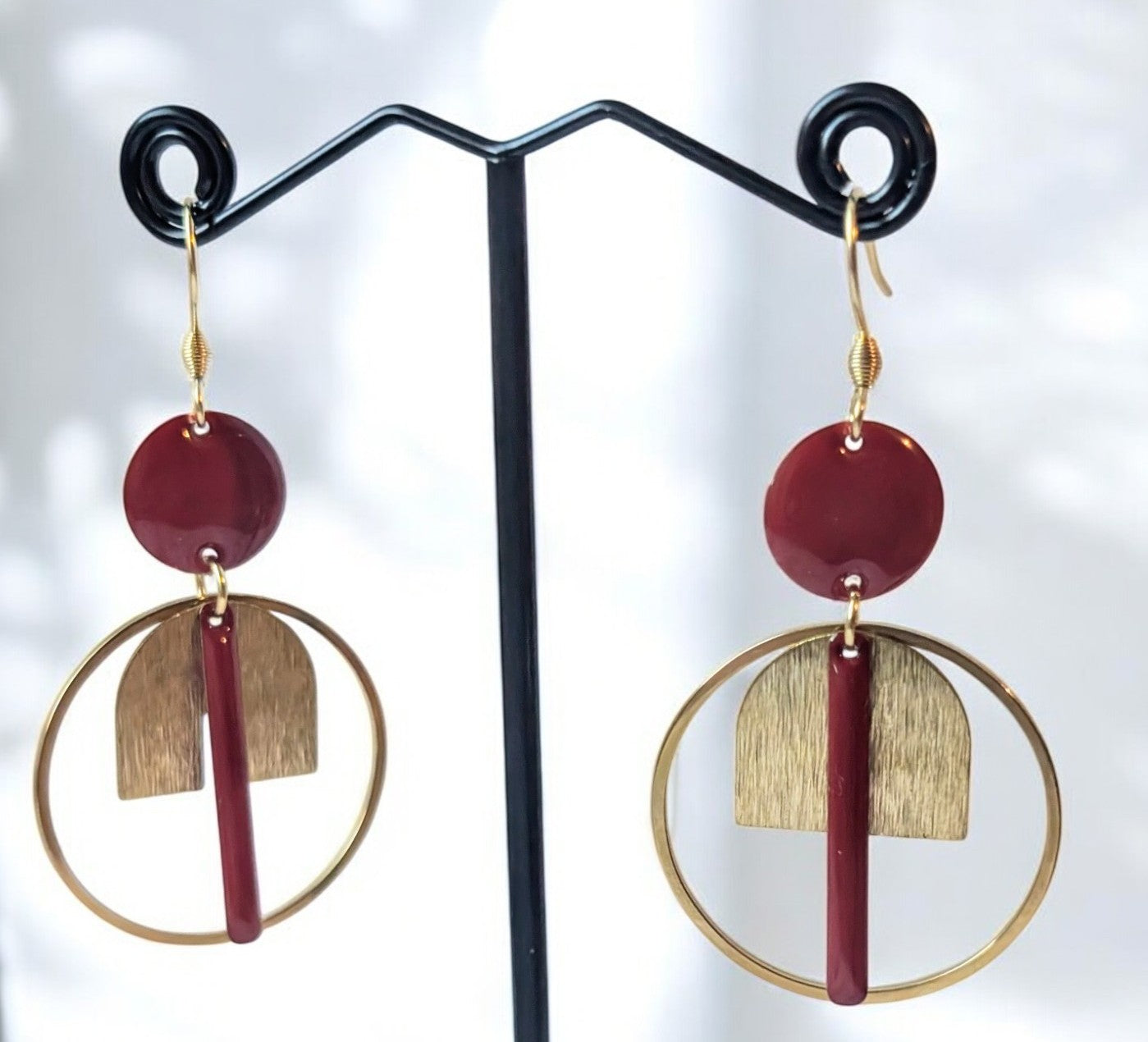 Boucles d’oreilles Japan en acier inoxydable doré et laiton émaillé rouge foncé, design raffiné avec cercle et baguettes élégantes.