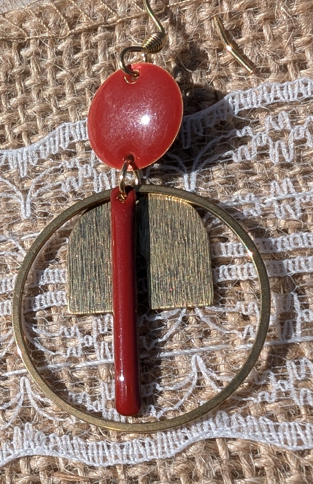 Zoom sur une des Boucles d’oreilles Japan en laiton émaillé rouge et acier inoxydable doré, au design moderne avec éléments géométriques.