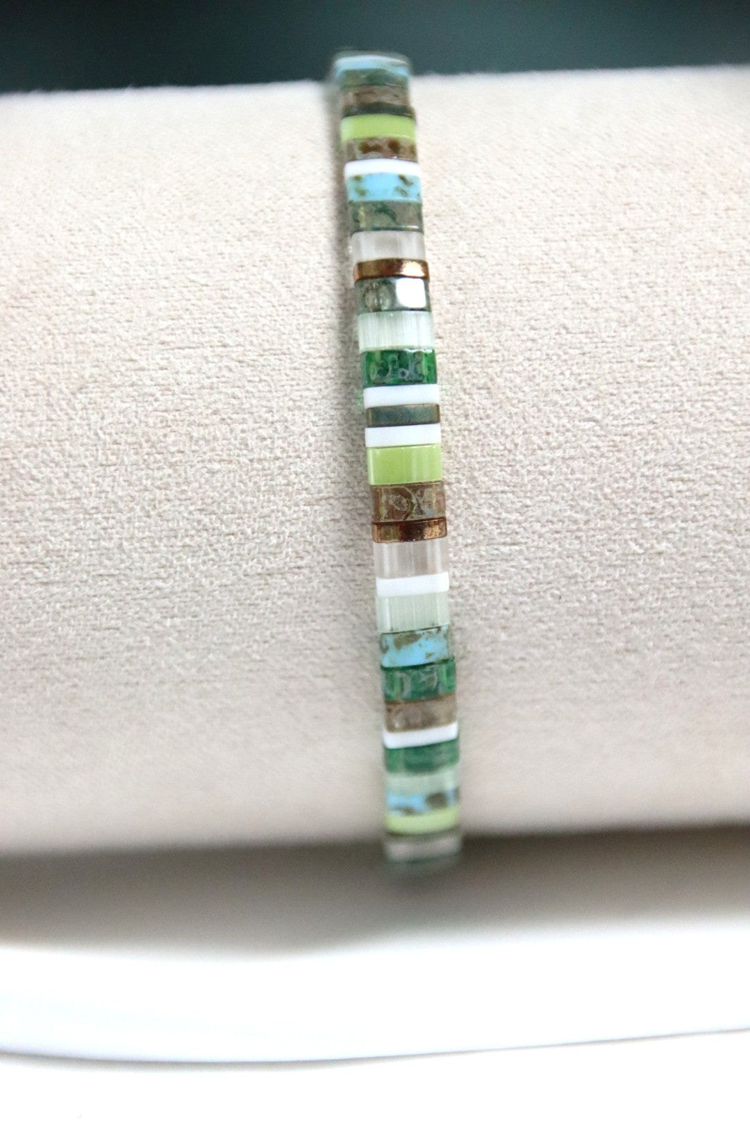 Gros plan sur le bracelet Kawa, perles aux nuances bronze, turquoise, vert et blanc.
