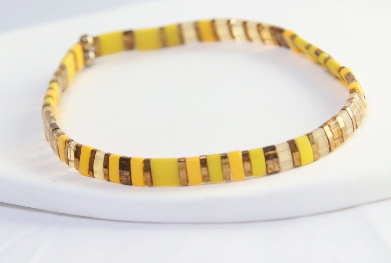 KIIRO, un bracelet en perles Miyuki aux nuances de jaunes , mats et transparents  où s'entremêle des perles bronze qui capte la chaleur du soleil et la douceur de la lumière. 