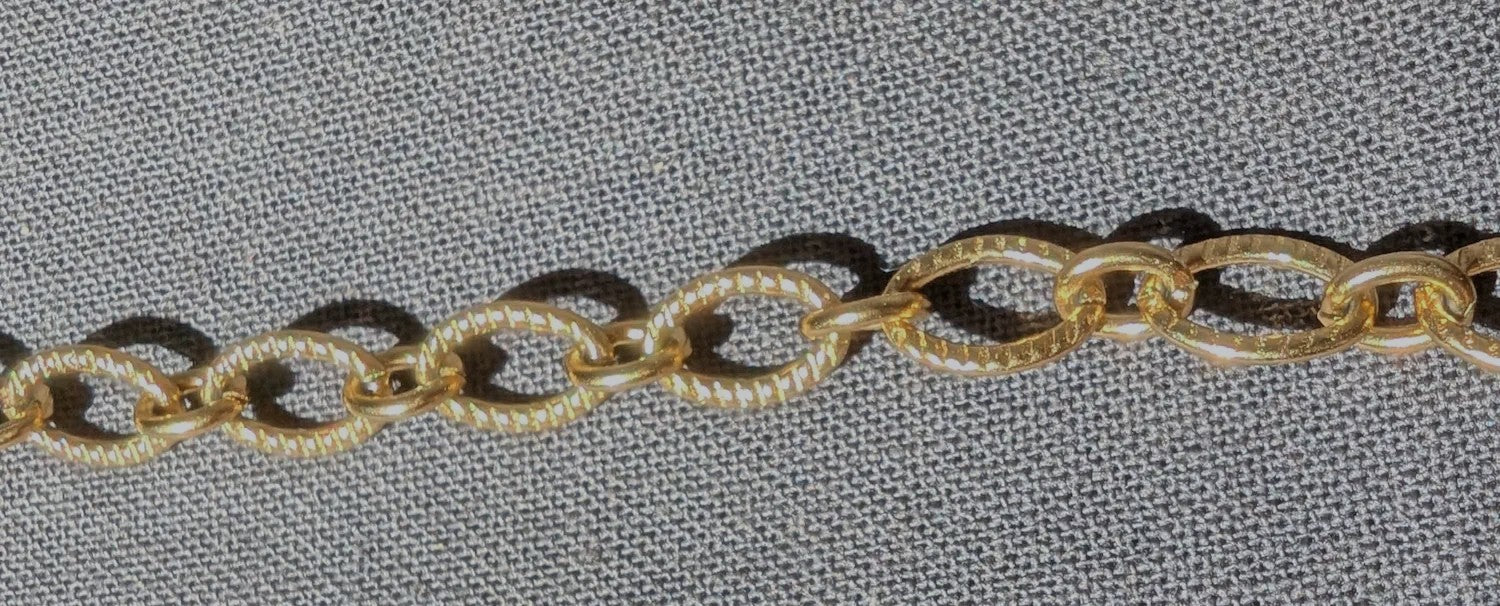 Zoom sur la chaîne ovale striée du collier Majorque, mettant en valeur sa texture élégante et originale.
