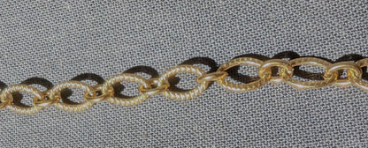 Zoom sur la chaîne ovale striée du collier Majorque, mettant en valeur sa texture élégante et originale.